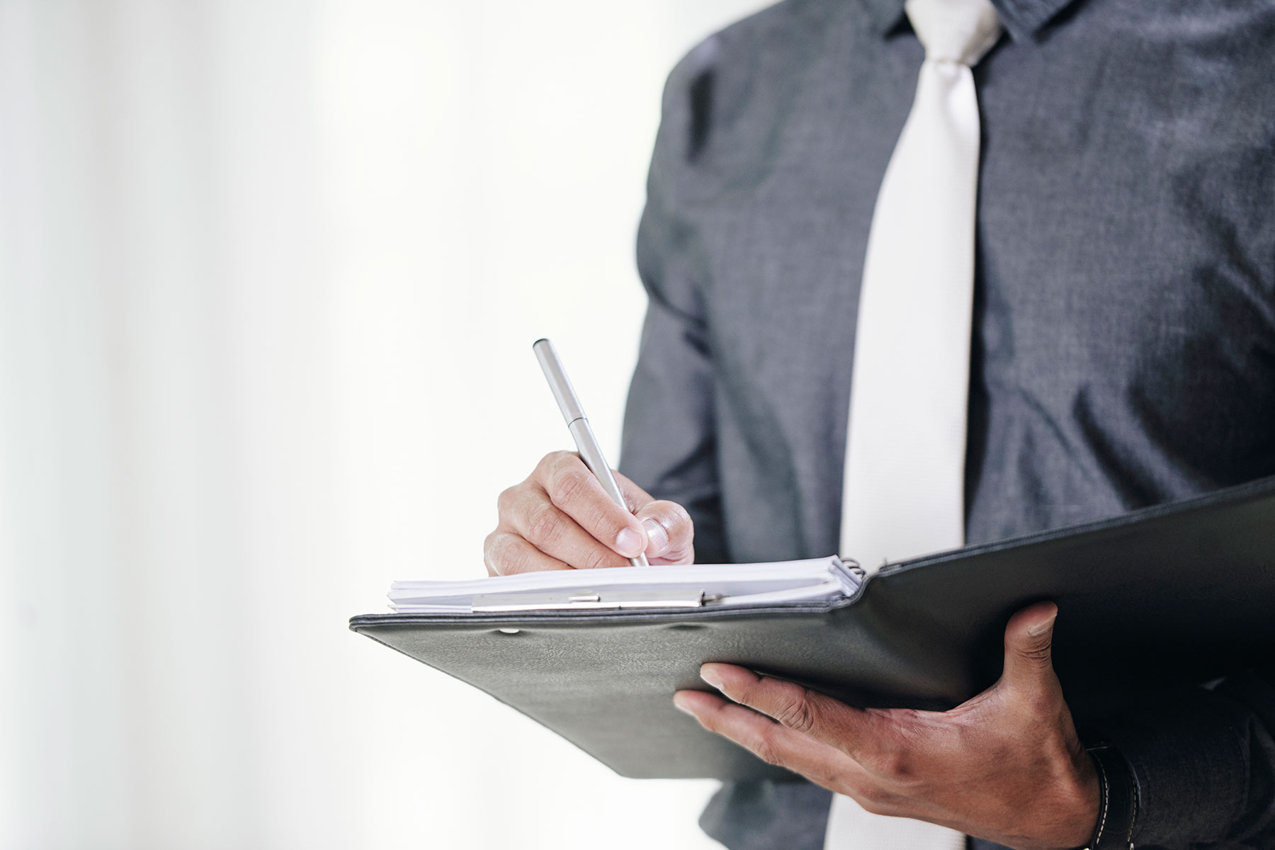 man writing in notebook