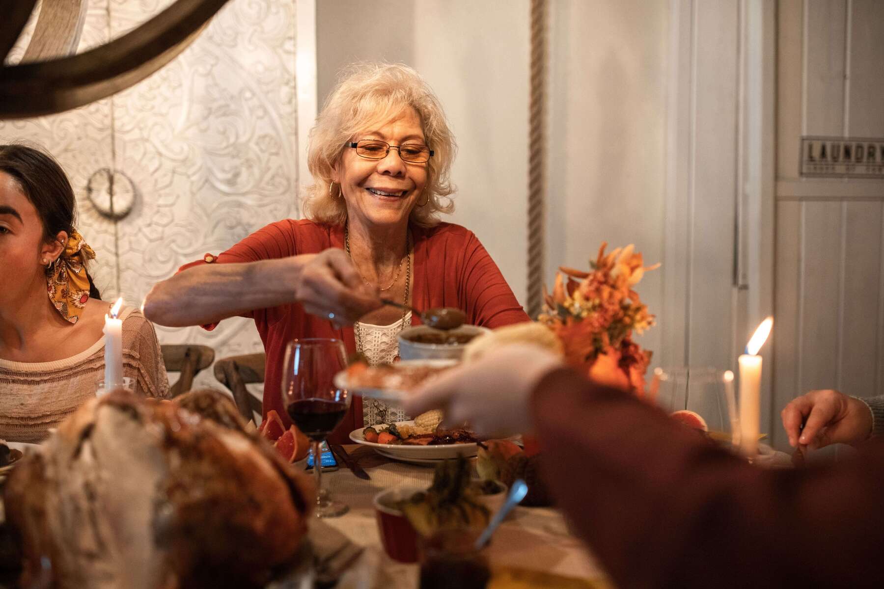 Senior woman enjoying a Thanksgiving dinner, sharing hearty meals with family indoors.